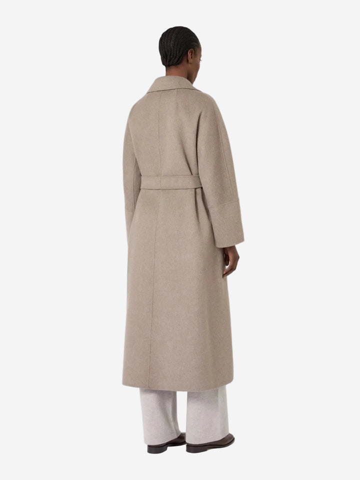 Person wearing a beige trench coat on a white background