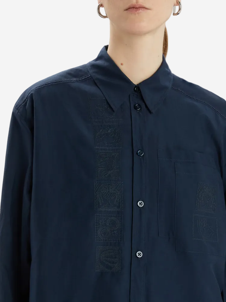 Navy blue shirt with embroidered design on a white background