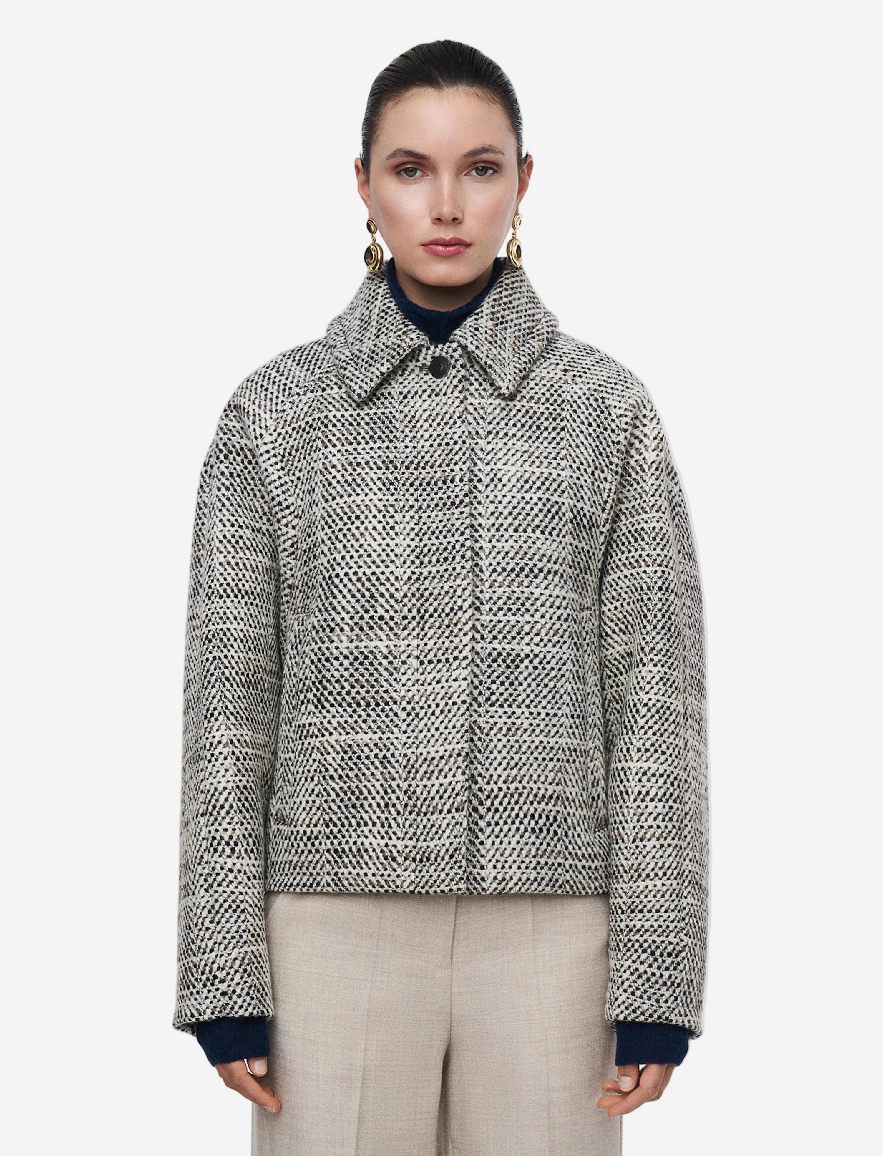 Woman wearing a patterned jacket on a plain background