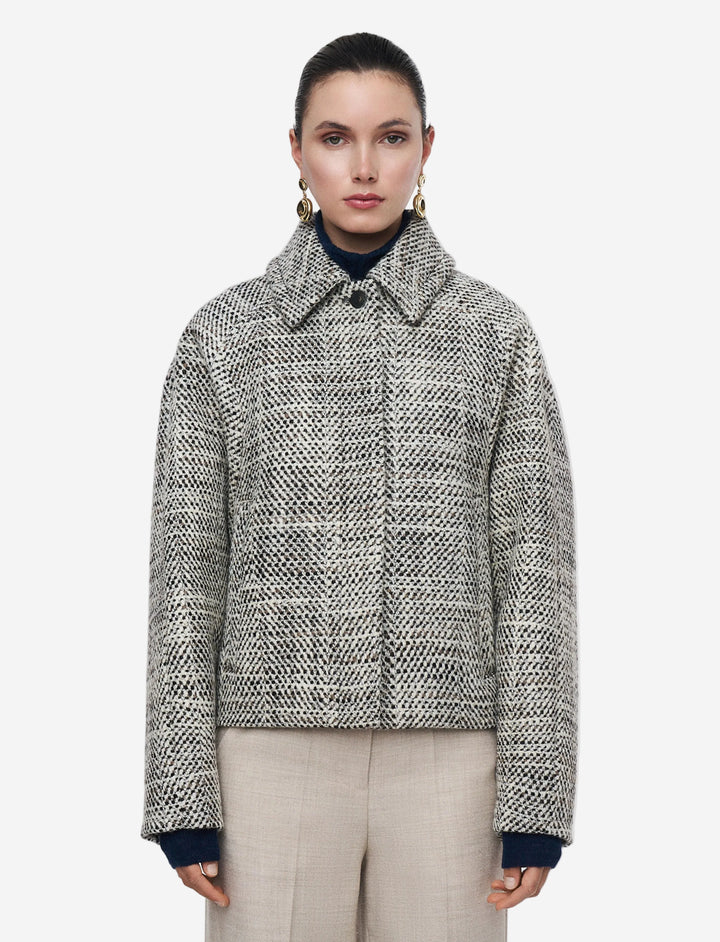 Woman wearing a patterned jacket on a plain background