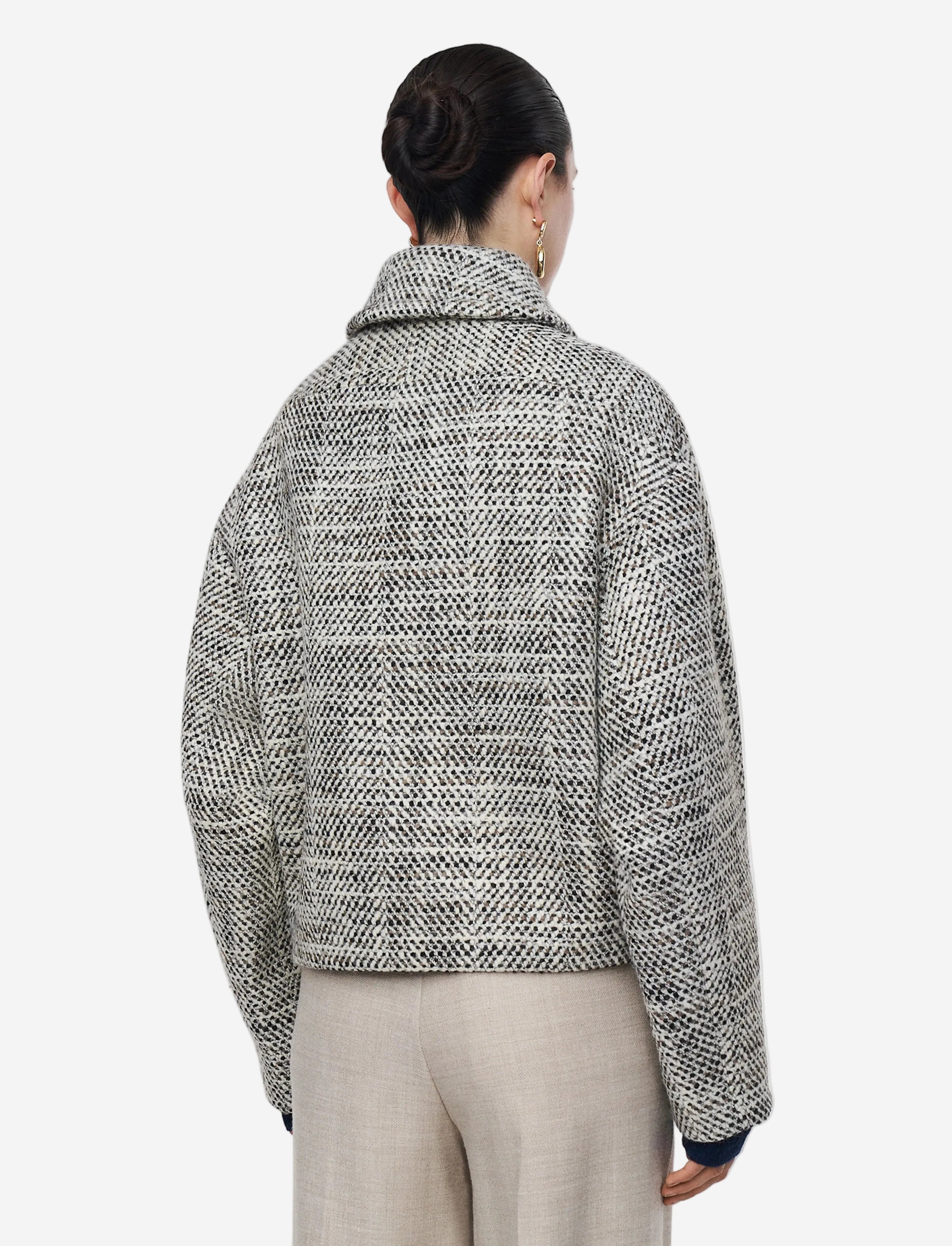 Person wearing a patterned jacket on a plain background