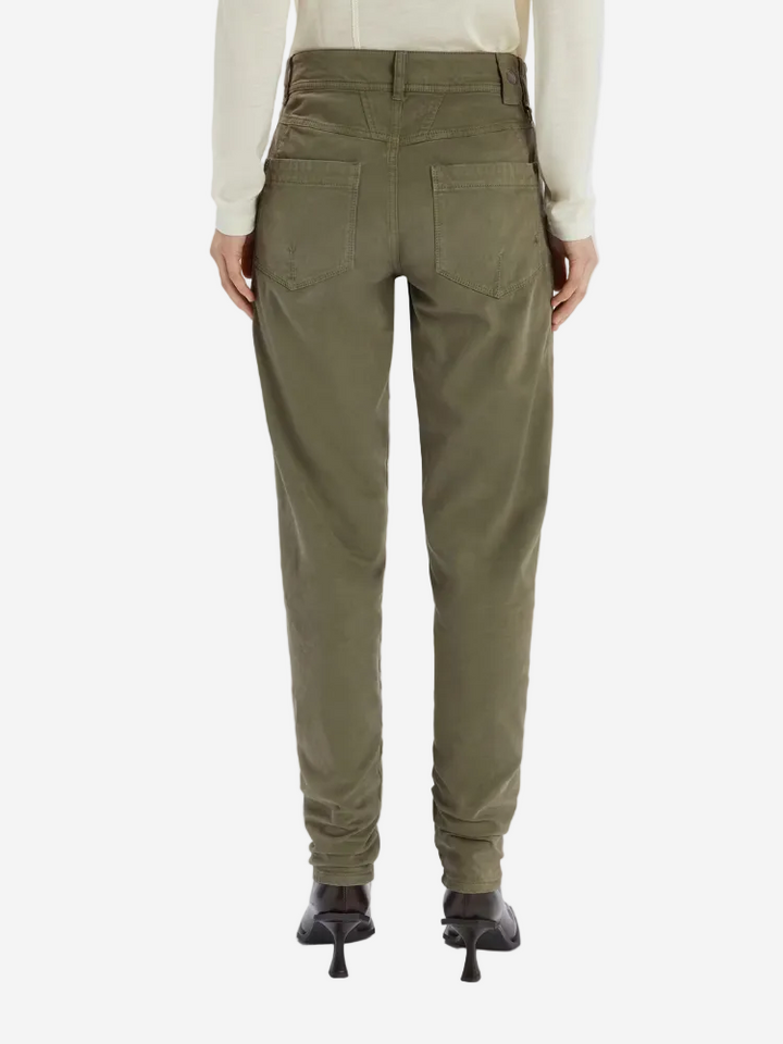 Green pants worn by a person on a white background