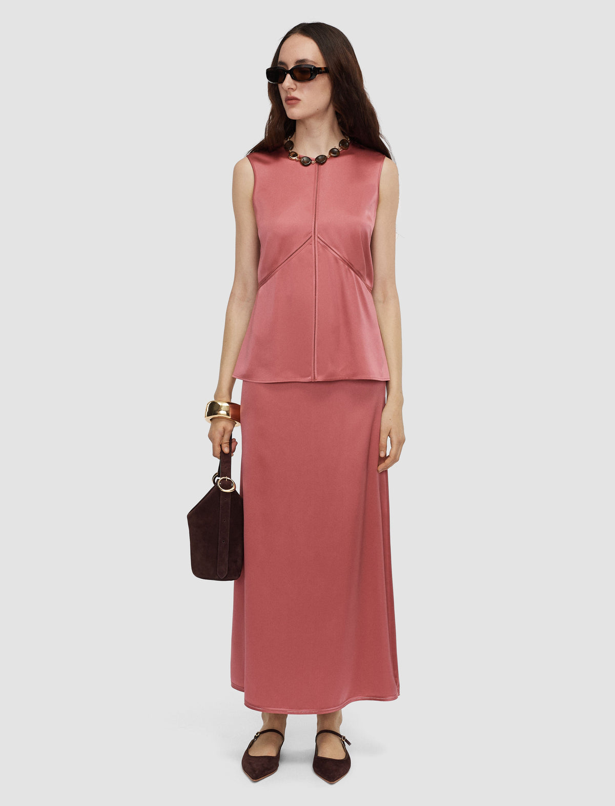 Model wears a pink silk satin sleeveless top by Joseph. 