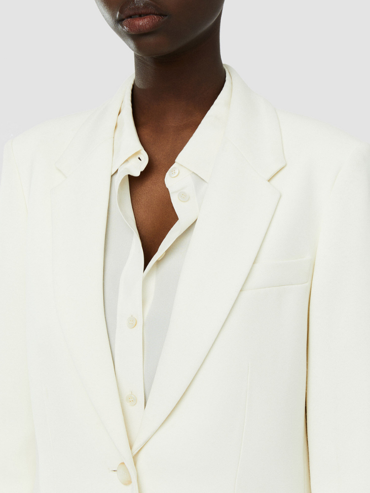 An ivory, single-breasted, regular fit blazer with shoulder padding, flap side pockets, and an inside chest pocket.