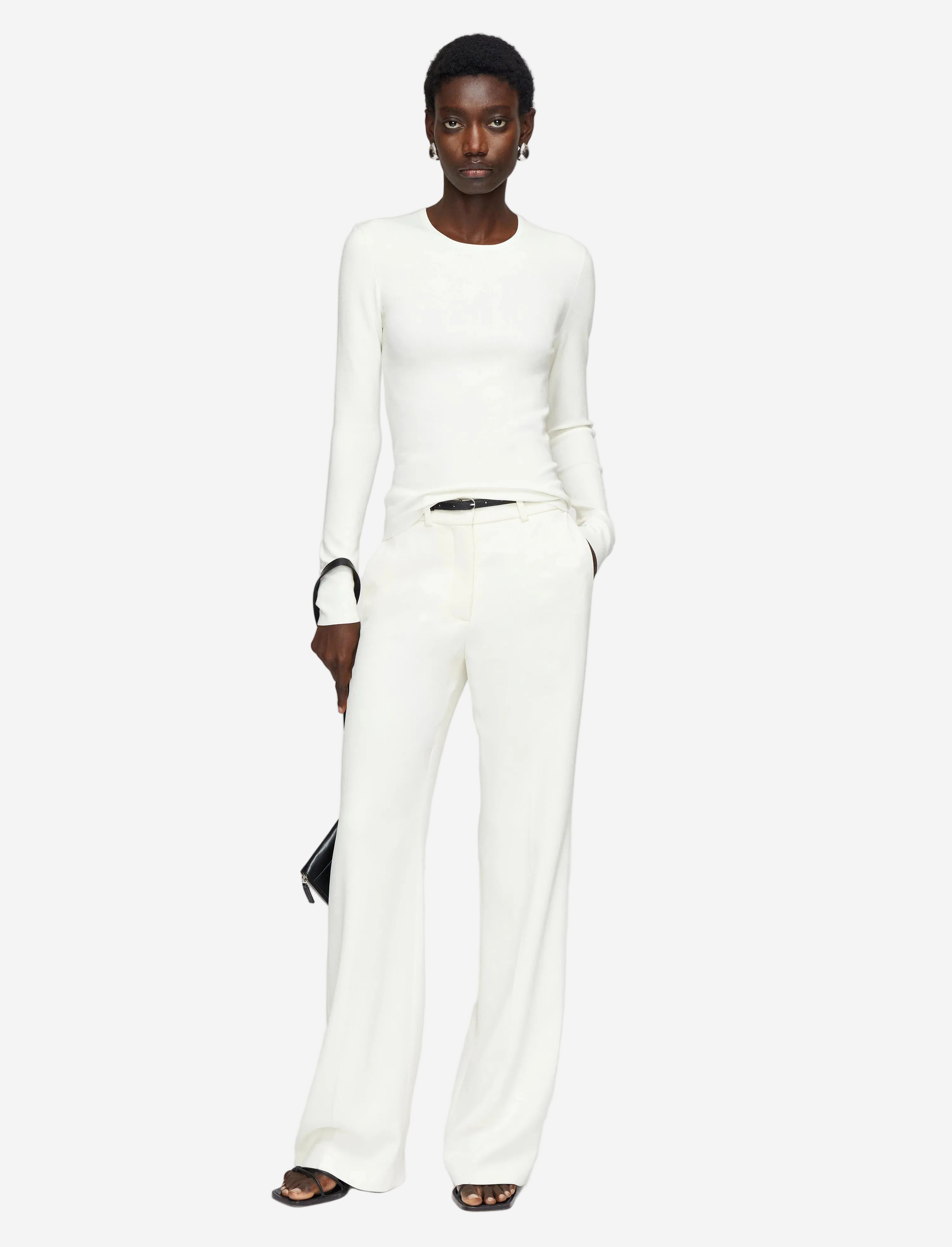 Person wearing a white outfit with a plain background
