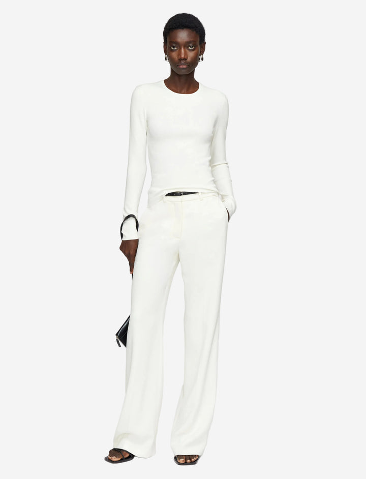 Person wearing a white outfit with a plain background