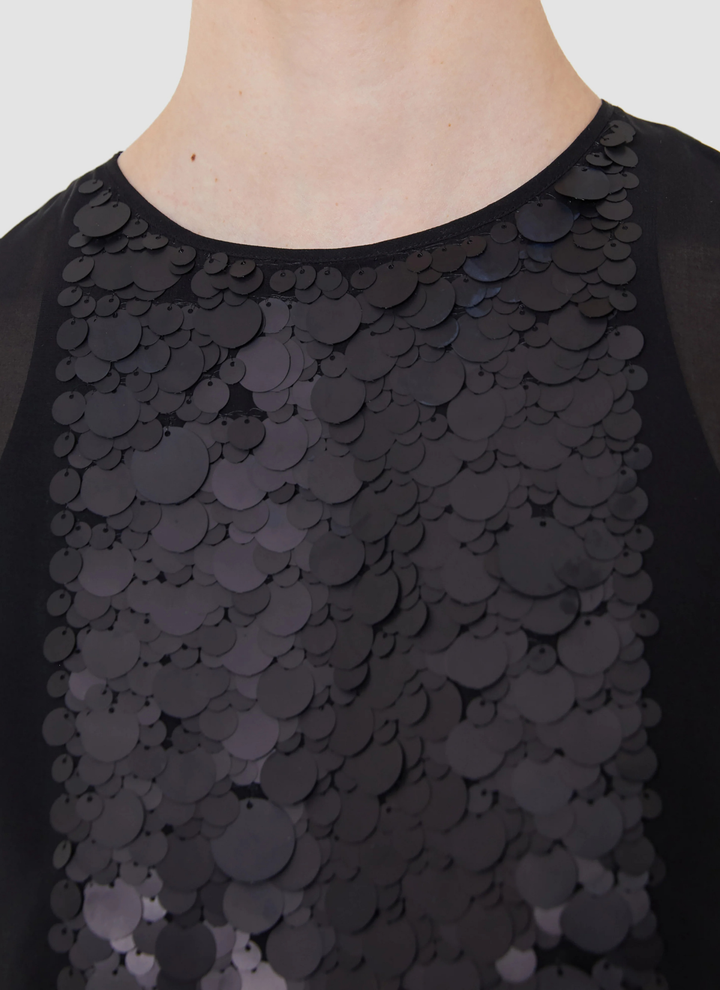 Black sequin top on a plain background