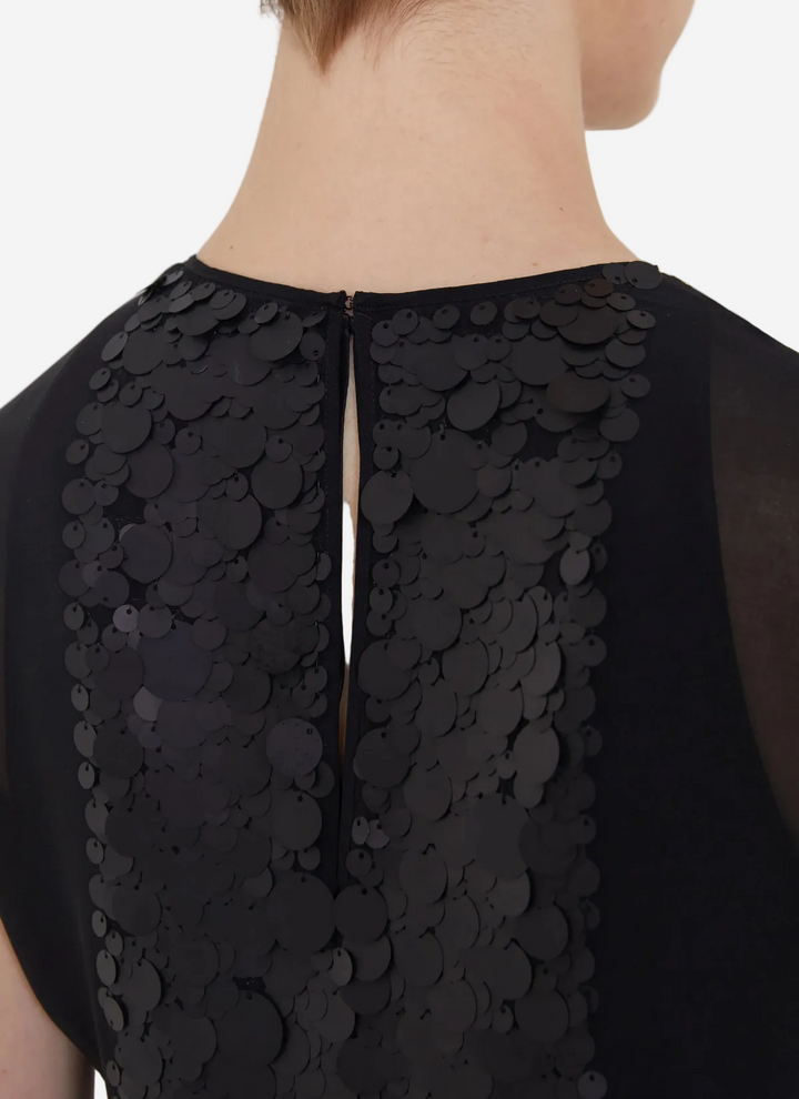 Black dress with intricate detailing on a plain background