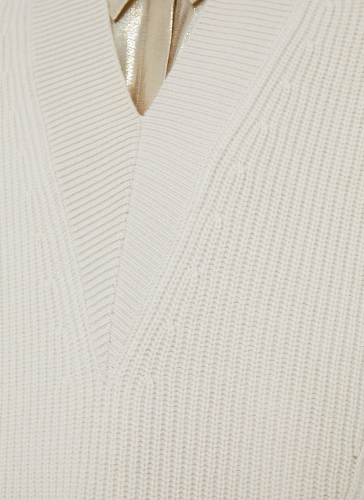 Close-up of a white ribbed knit sweater with a V-neck