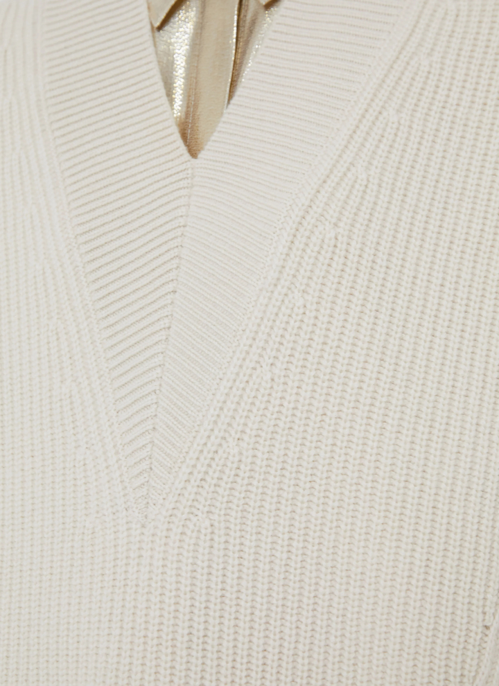 Close-up of a white ribbed knit sweater with a V-neck