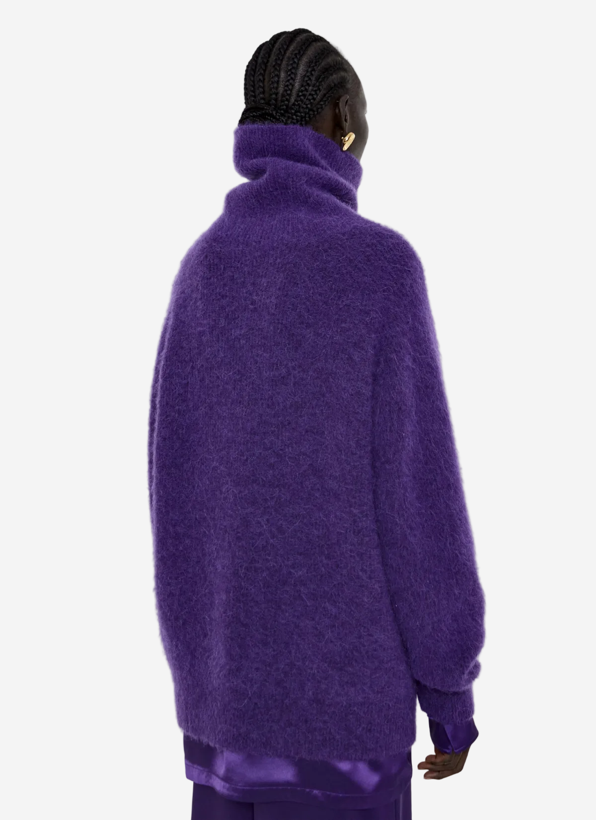 Person wearing a purple sweater on a light gray background