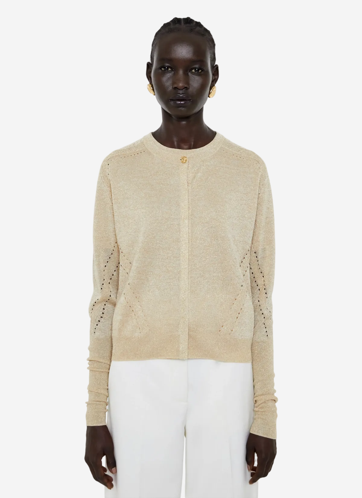 Person wearing a beige cardigan with cut-out details on a white background