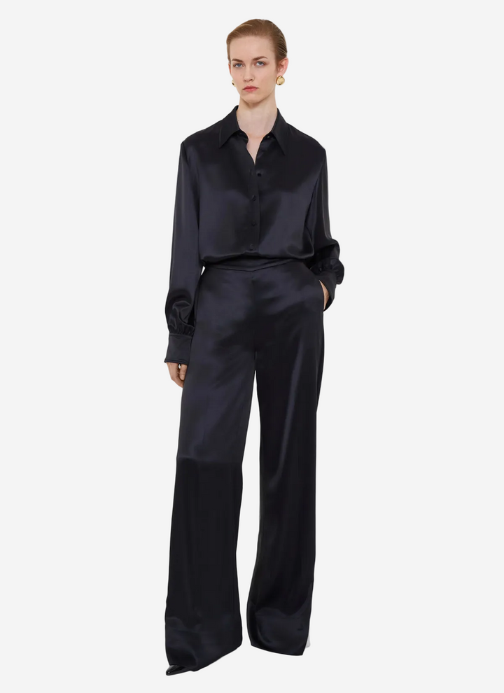 Person wearing a black satin outfit on a white background