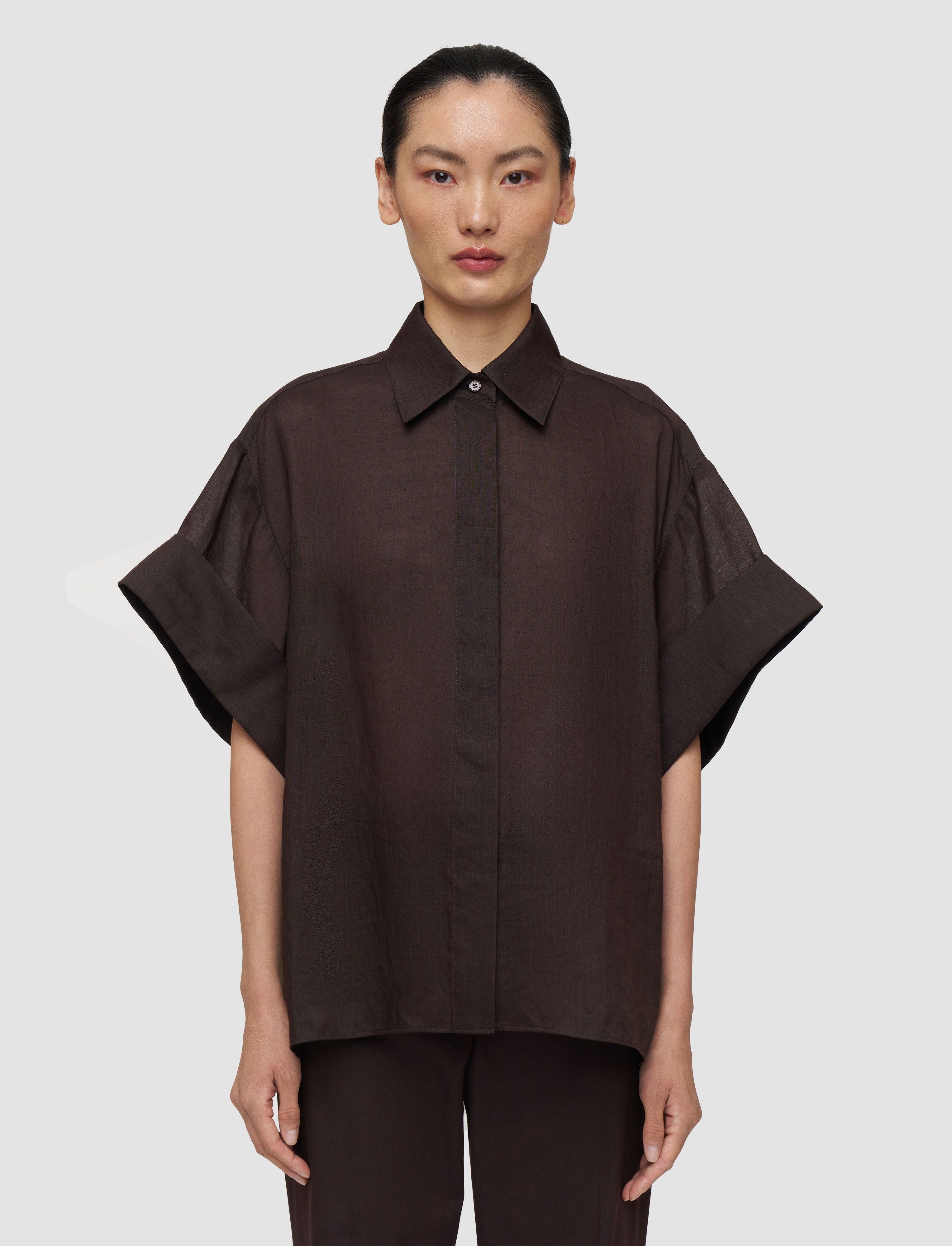 Person wearing a brown shirt on a plain background