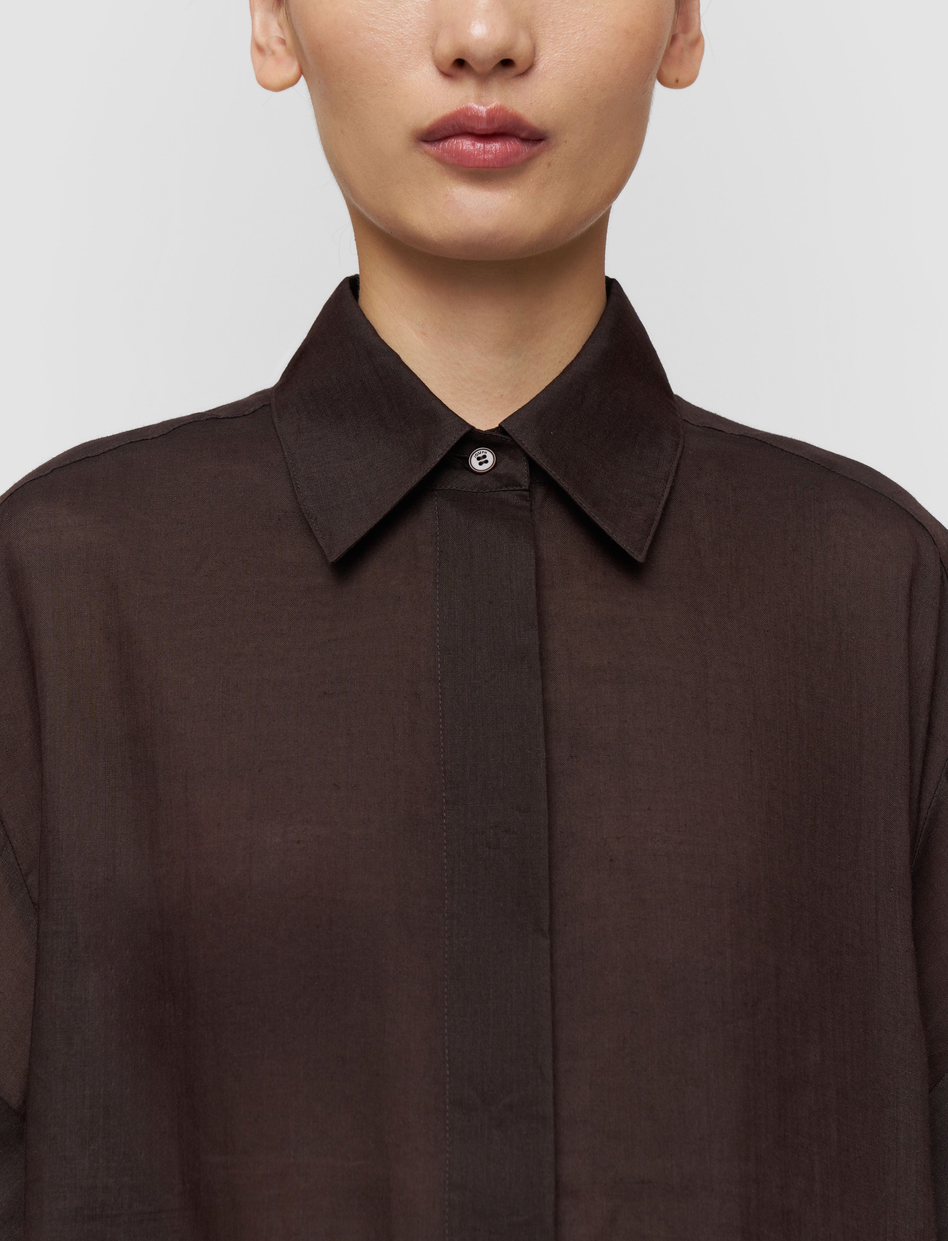 Brown shirt worn by a person on a plain background