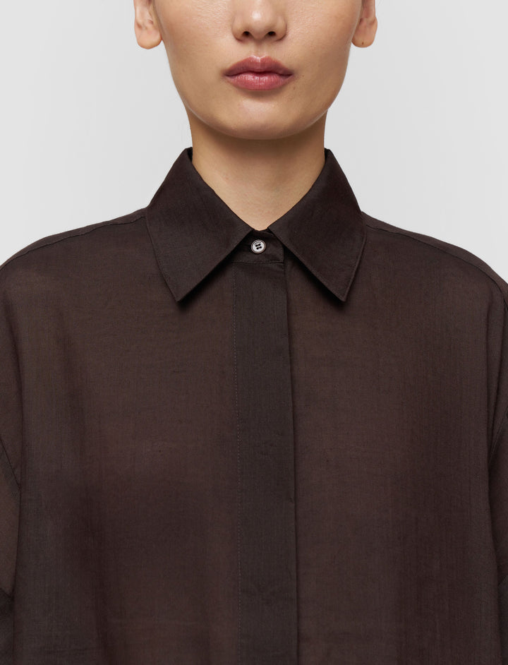 Brown shirt worn by a person on a plain background