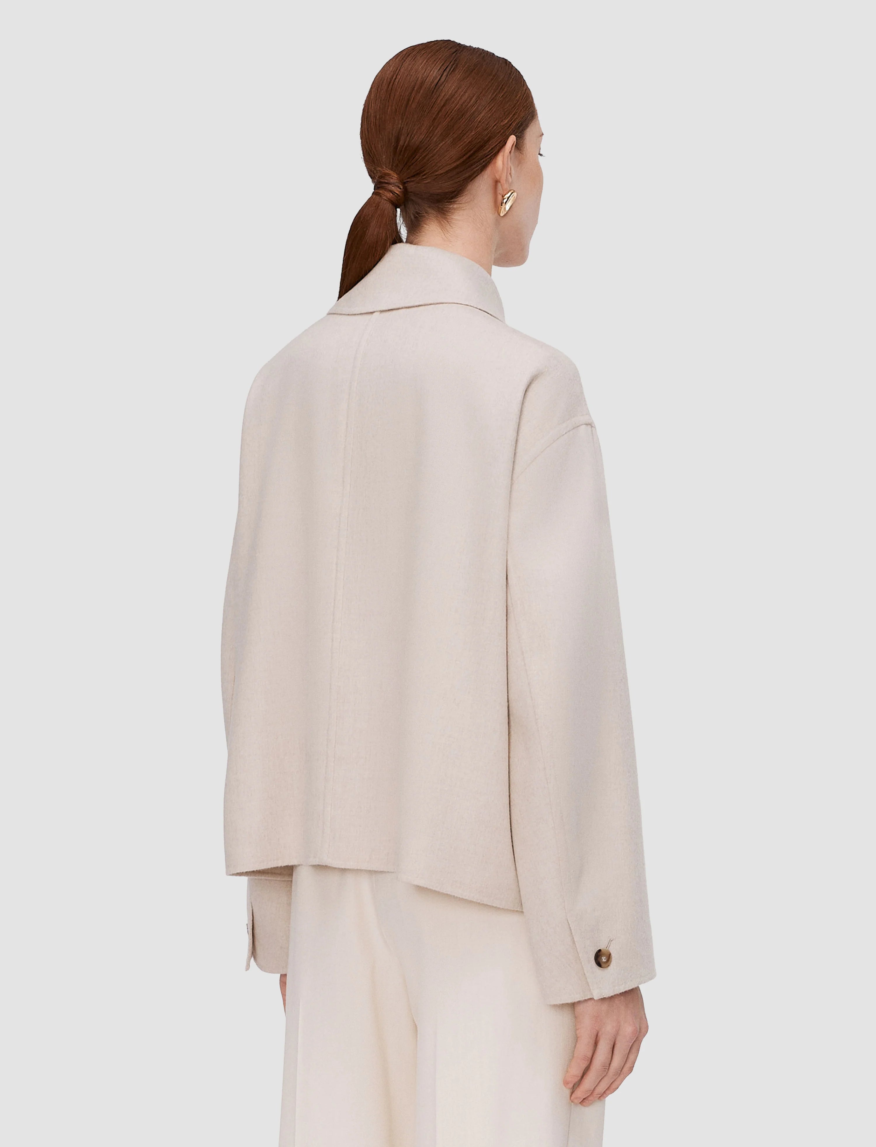 Person wearing a beige suit on a white background