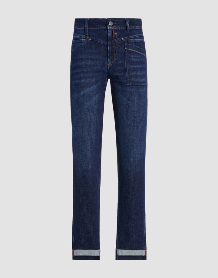 A pair of dark blue denim jeans with a straight-leg fit, shown flat against a solid black background. The jeans feature a subtle whiskering effect on the upper thighs and a rolled cuff at the hem revealing a light gray inner lining.