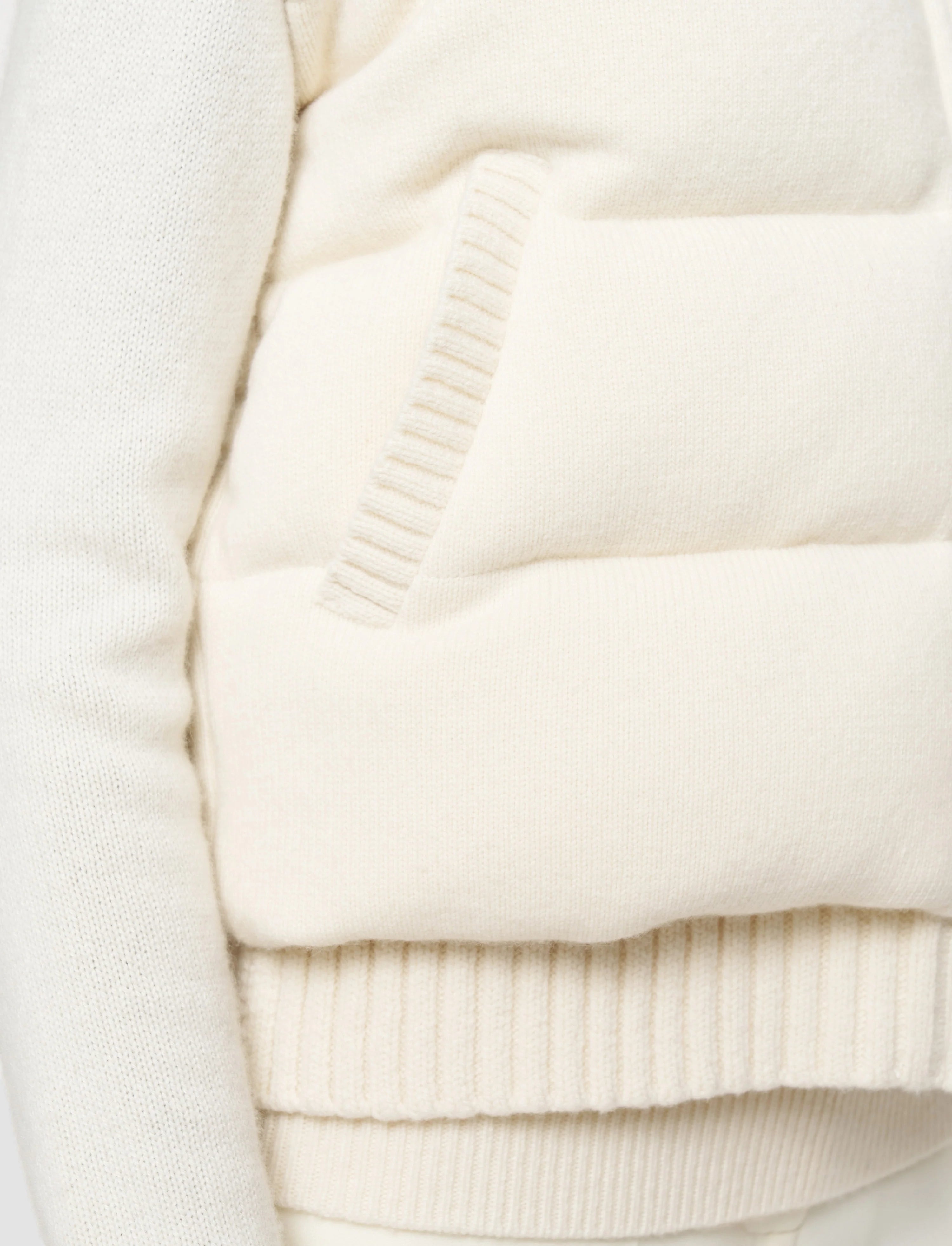 Close-up of a cream-colored sweater with ribbed texture