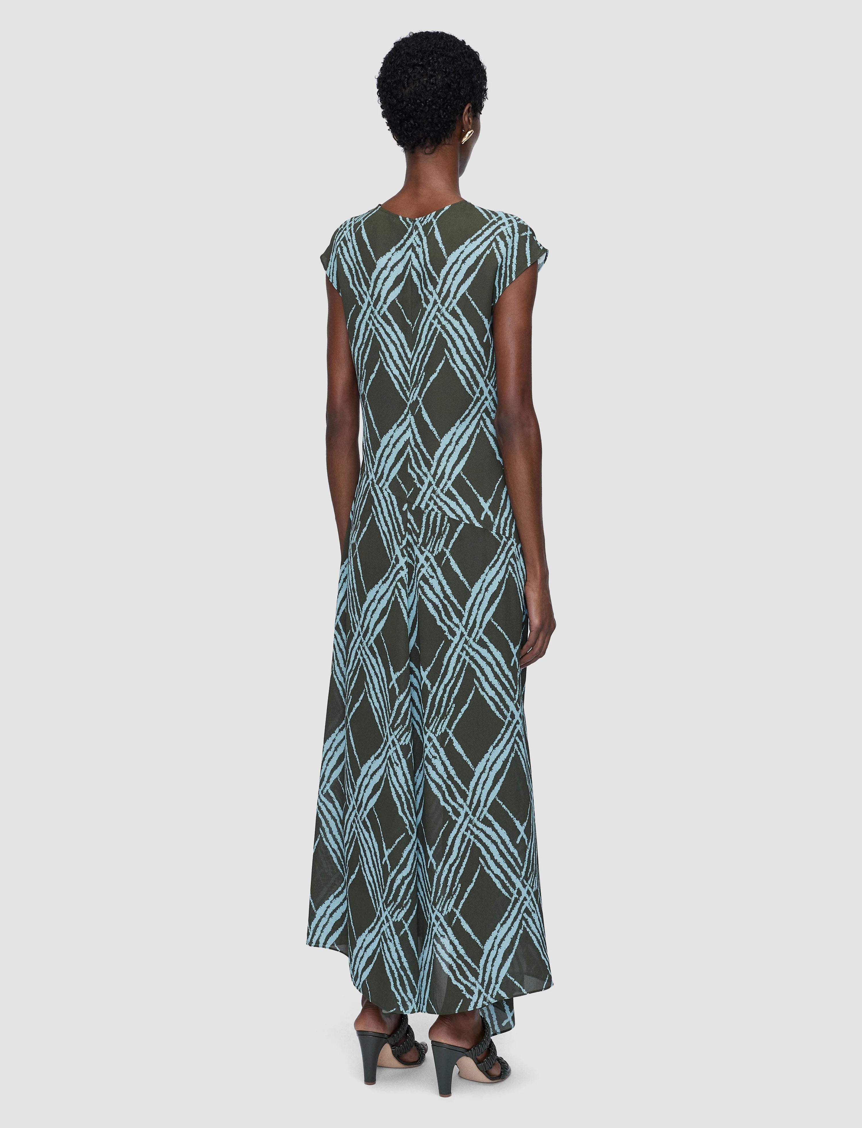 Woman wearing a patterned dress on a white background
