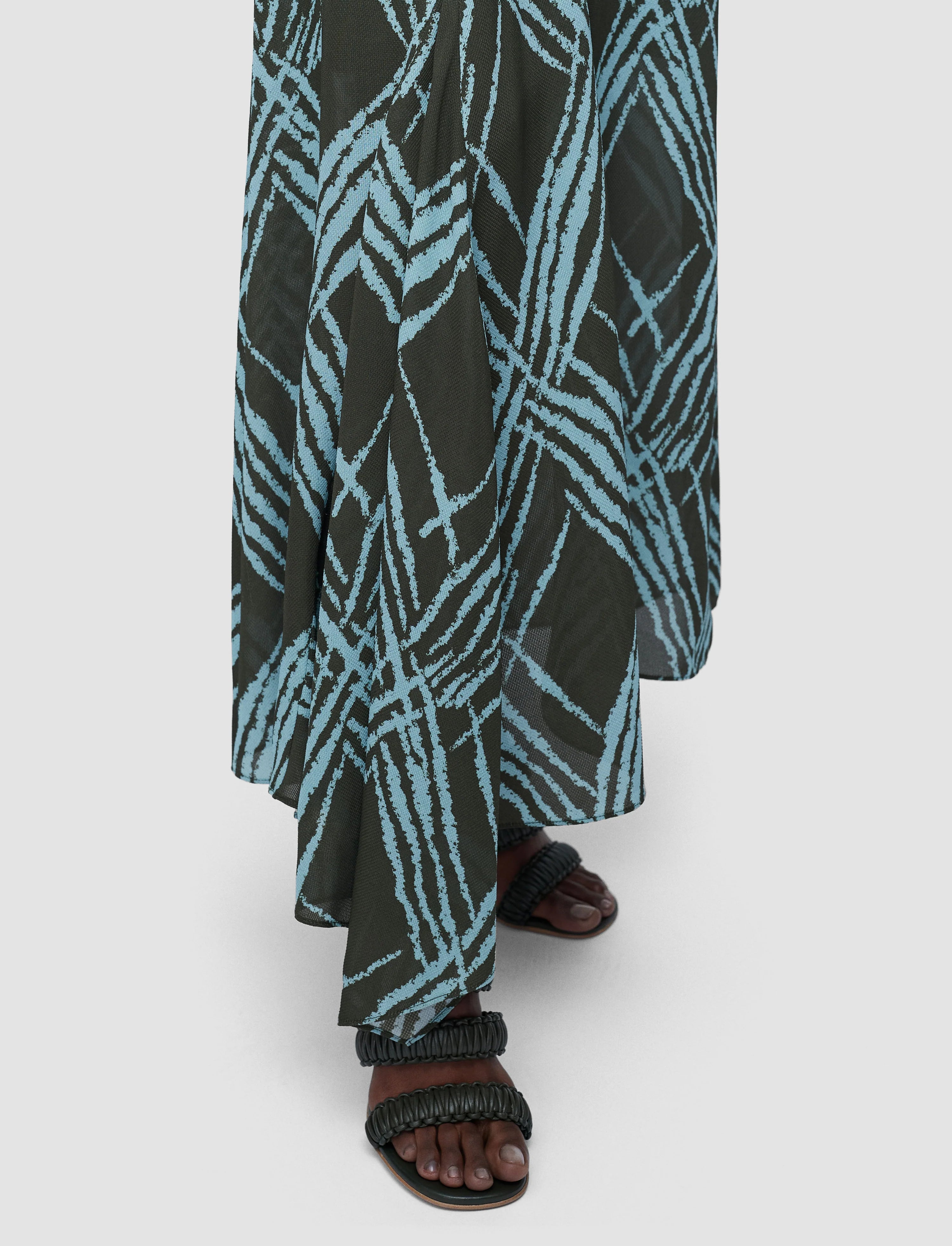 Long black and blue patterned skirt worn by a person on a white background