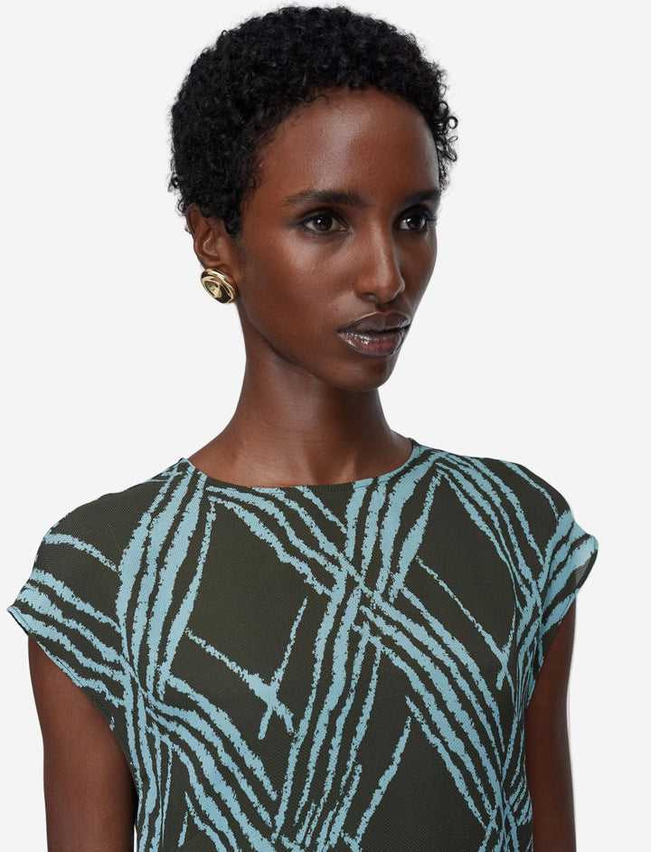 Woman wearing a patterned dress against a plain background