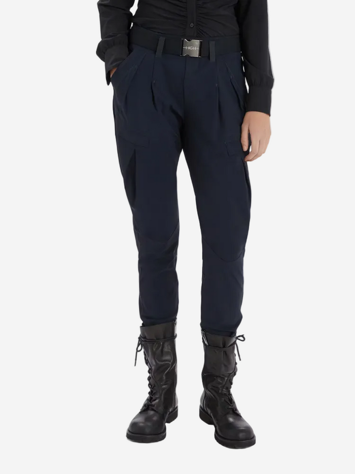 Person wearing dark blue pants and black boots on a white background