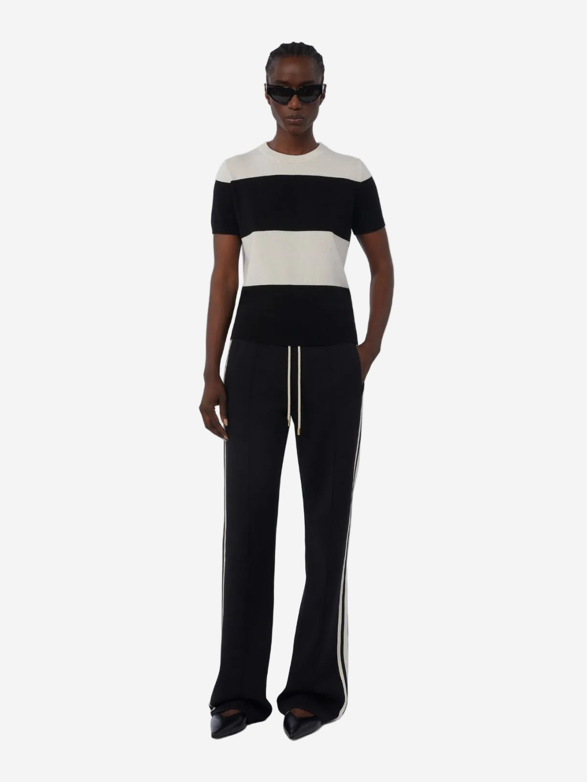 Person wearing a black and white outfit with a white background