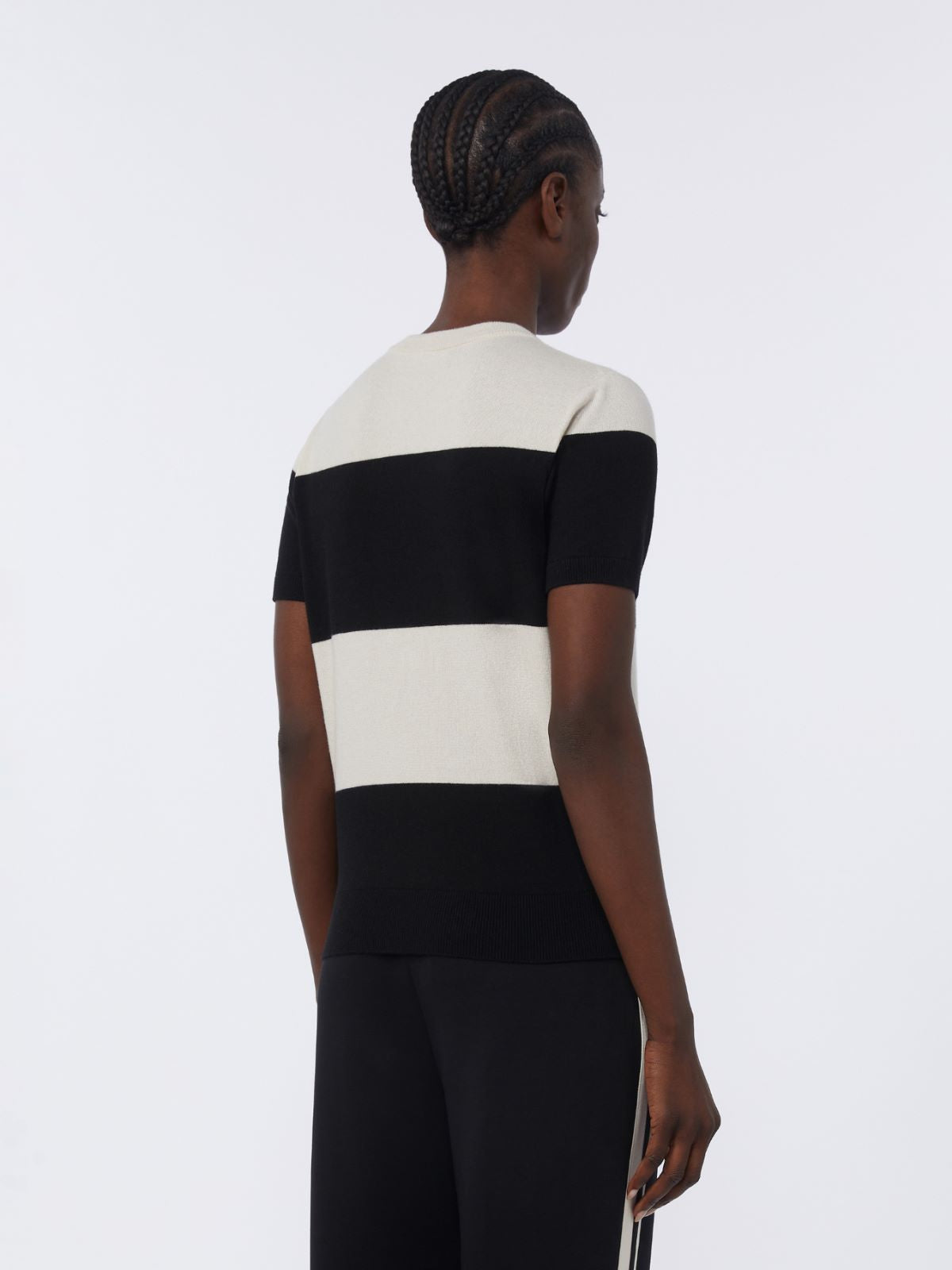Person wearing a black and white striped dress on a plain background