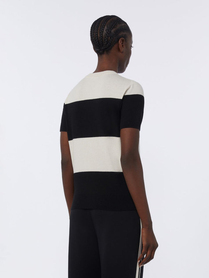 Person wearing a black and white striped dress on a plain background