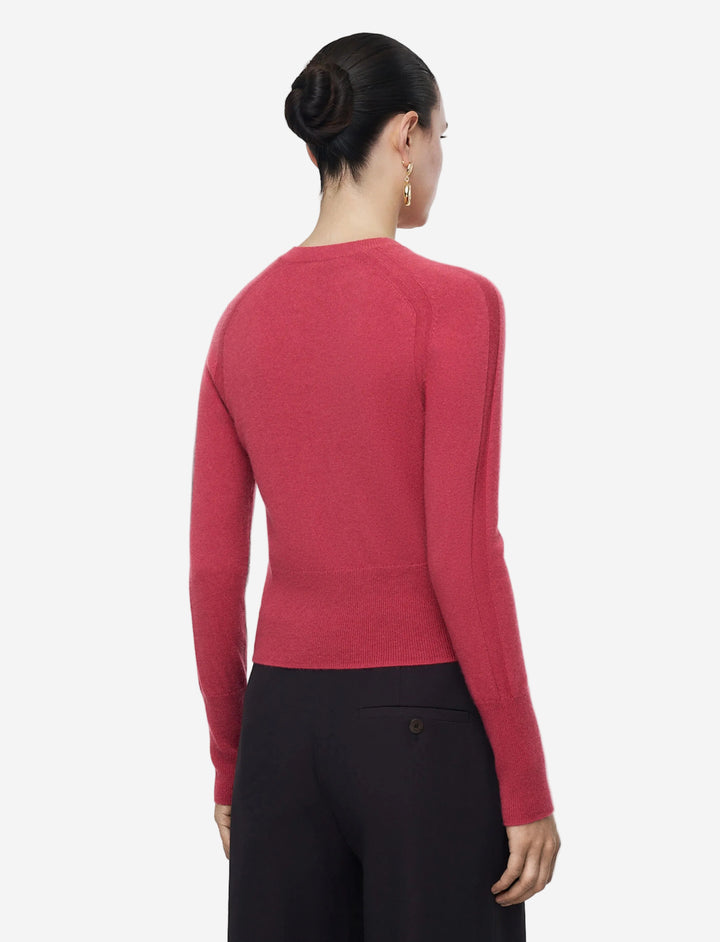 Person wearing a red sweater and black pants on a white background