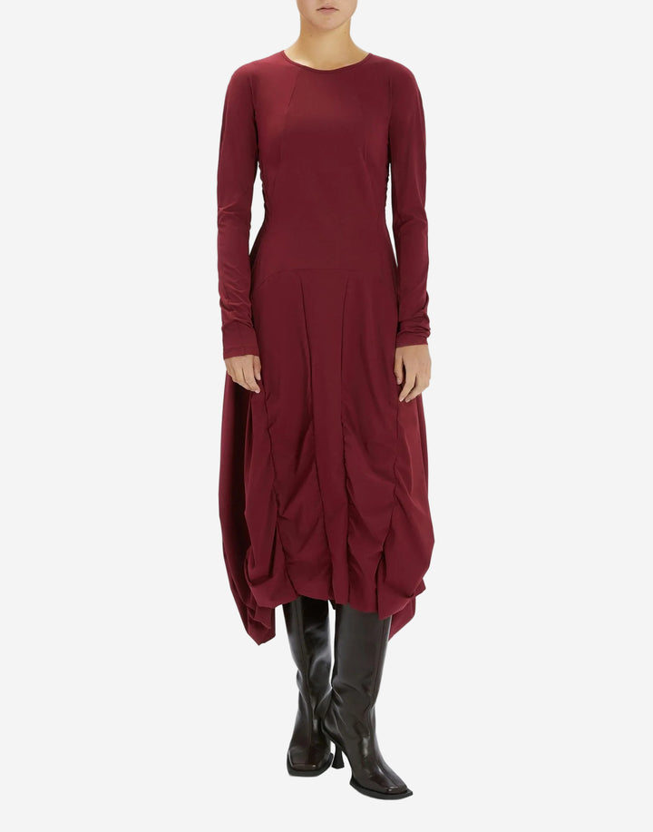 Maroon dress with long sleeves and a unique skirt design on a white background
