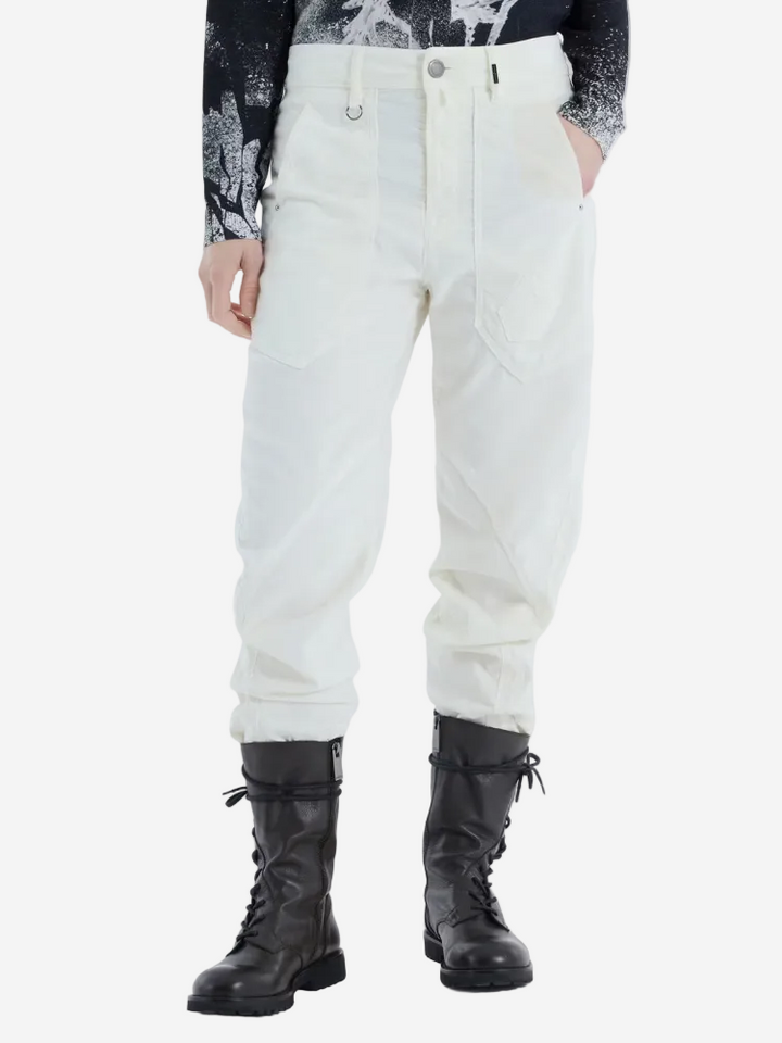 Person wearing white pants and black boots on a white background