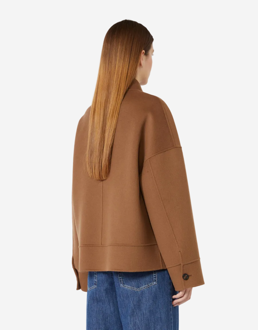 Person wearing a brown jacket and blue jeans on a white background