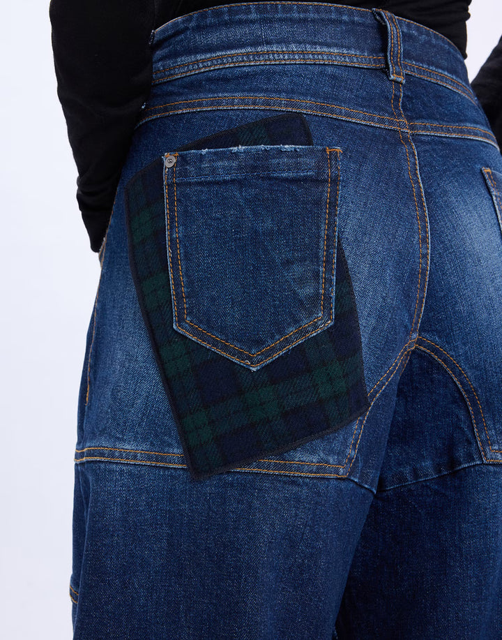 Close-up of the green tartan panel behind the back pocket of the HIGH Snowdrift jeans