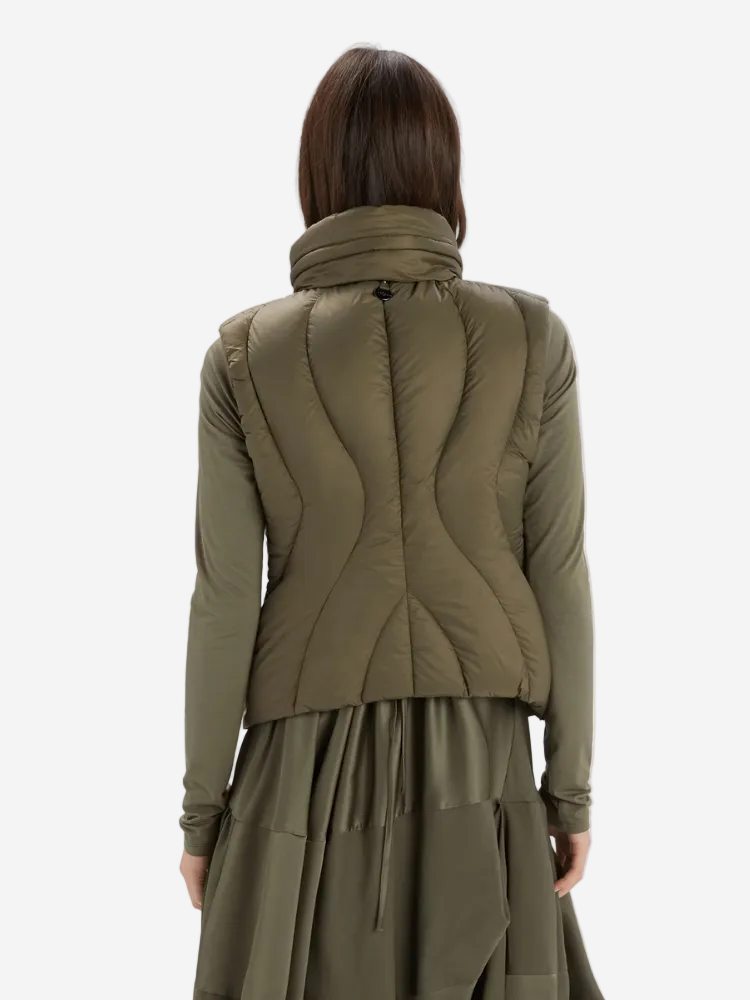 Person wearing a green quilted jacket on a white background