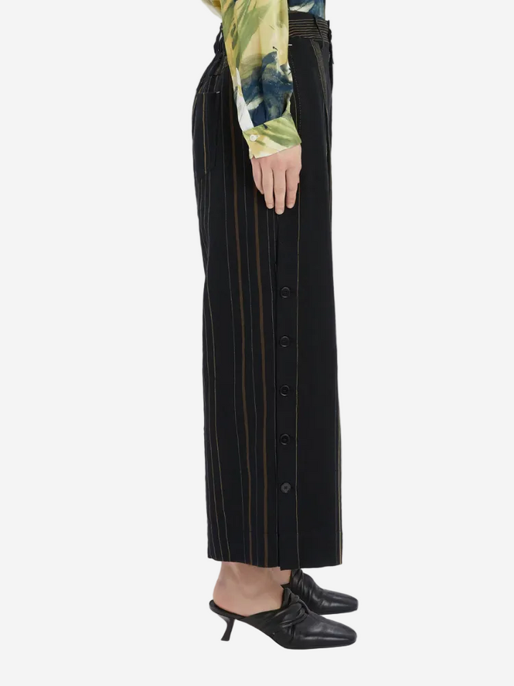 Black pinstripe pants worn by a person on a white background