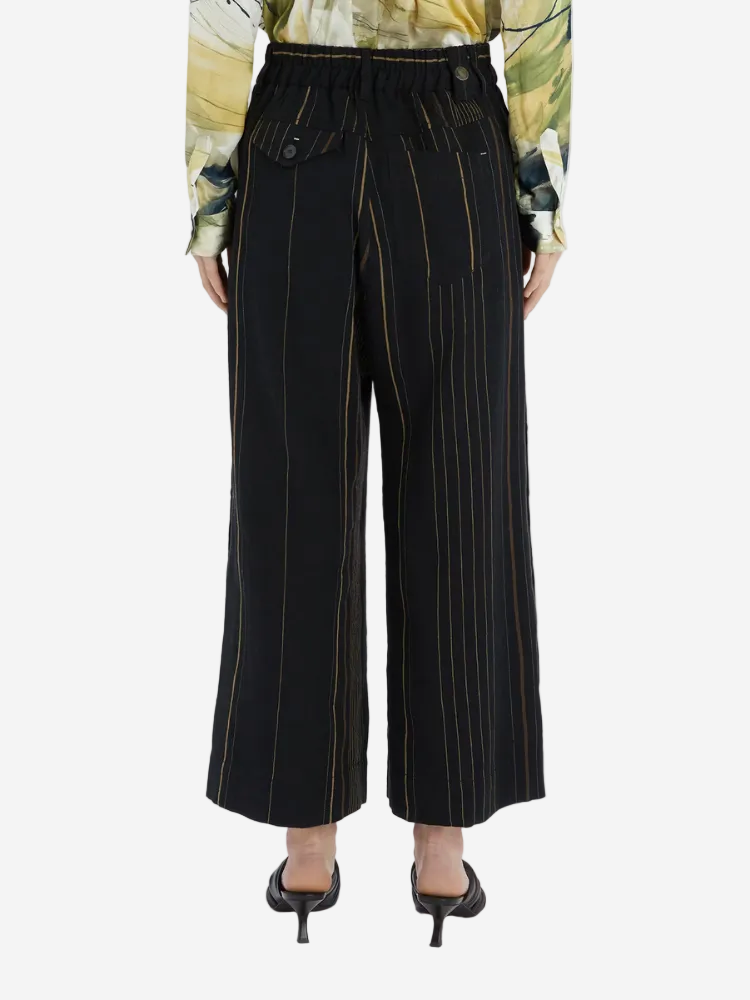 Black pinstripe pants worn by a person on a white background