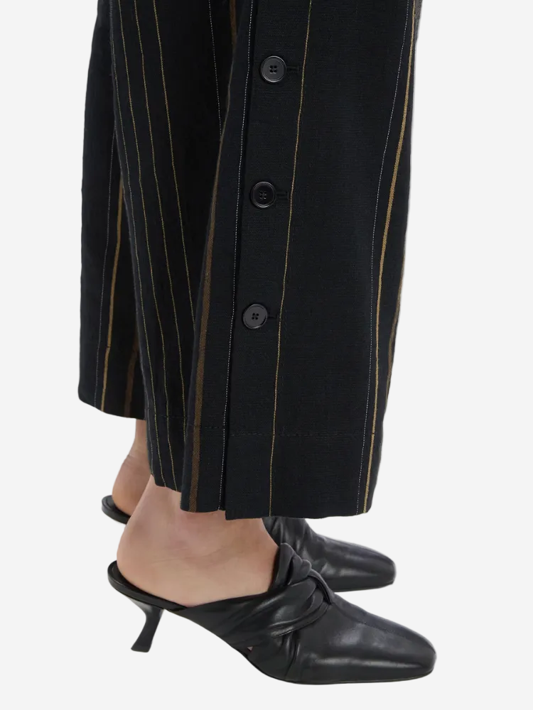 Person wearing a black pinstripe coat with a white background