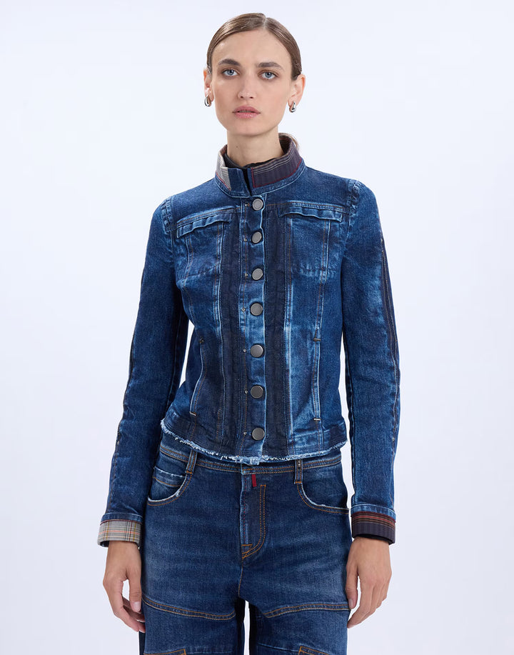 A model wearing a dark blue denim jacket with a mandarin collar and button front, paired with matching blue jeans, against a plain white studio background.