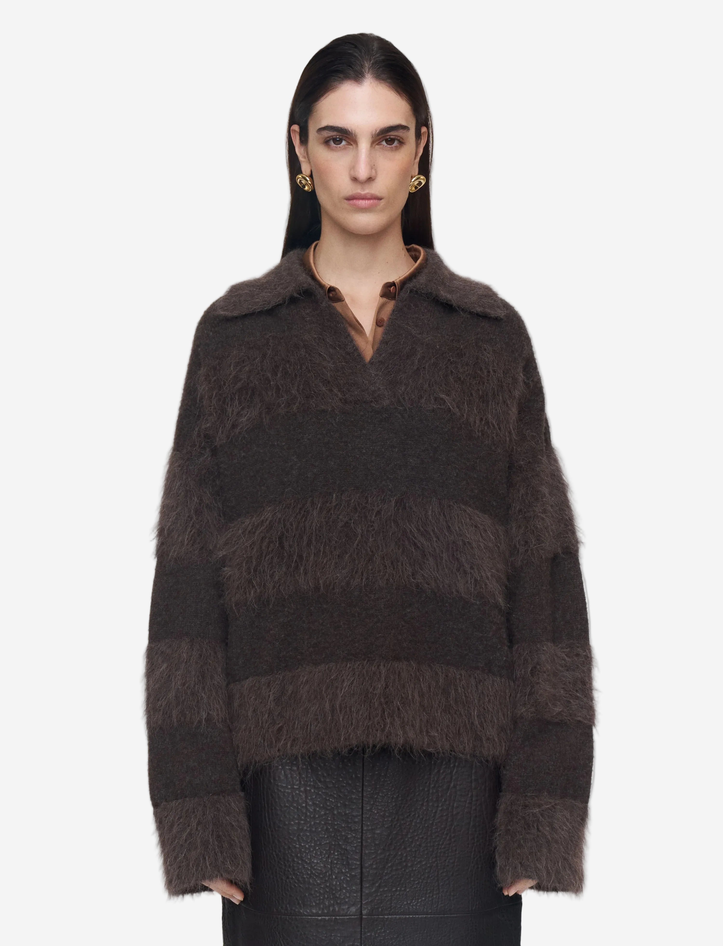 Woman wearing a brown textured sweater on a plain background