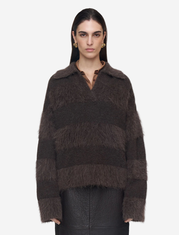 Woman wearing a brown textured sweater on a plain background