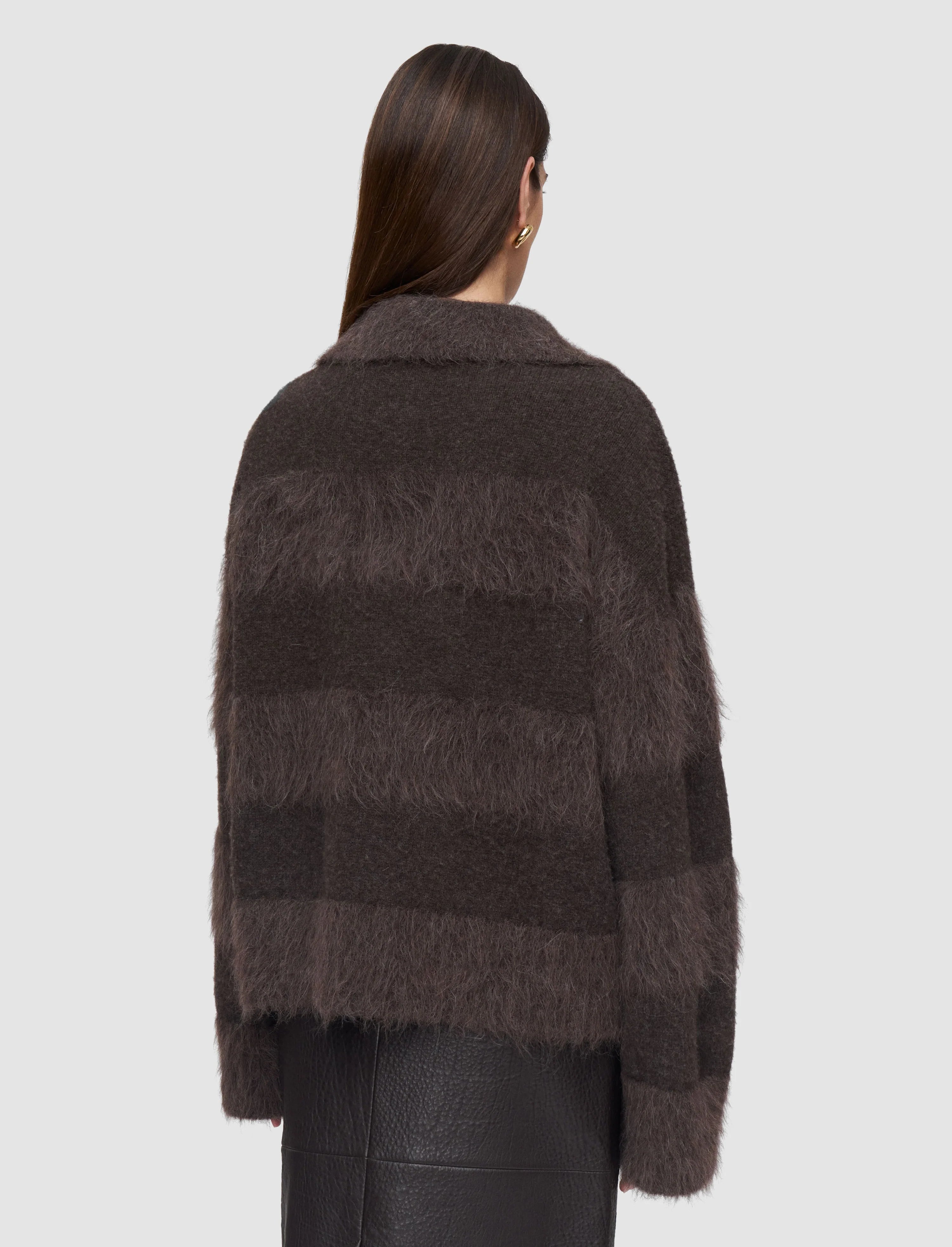 Woman wearing a dark brown textured sweater against a light gray background