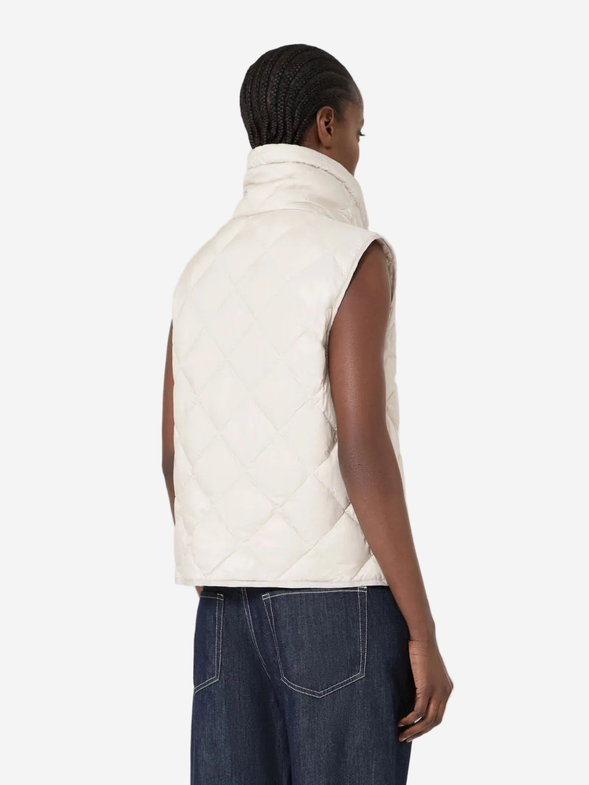 Person wearing a white quilted vest on a white background