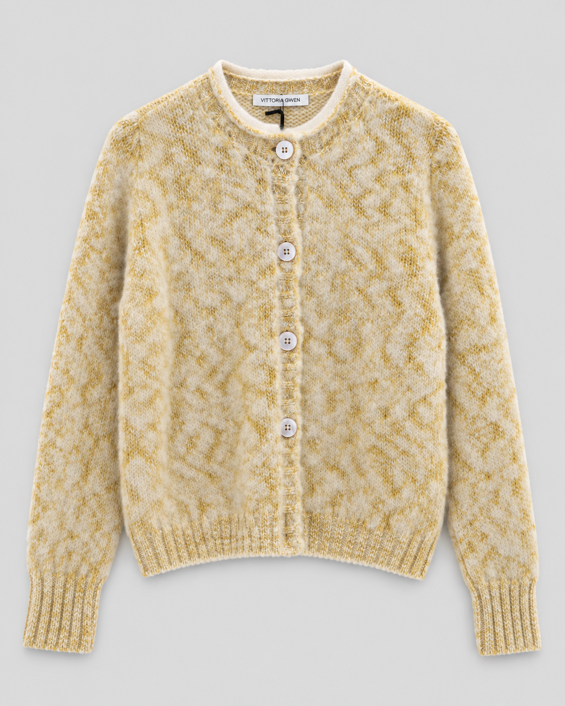 A cream and mustard yellow textured knit cardigan sweater with a button-up front, laid flat on a light gray background.