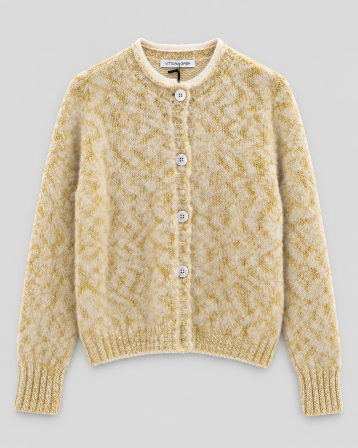 A cream and mustard yellow textured knit cardigan sweater with a button-up front, laid flat on a light gray background.